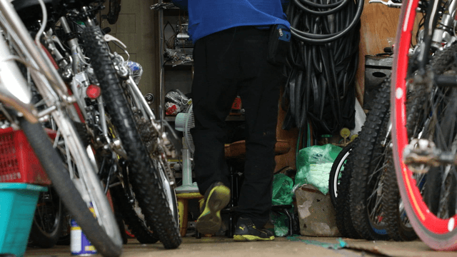 Person organizing bicycles in a workshop