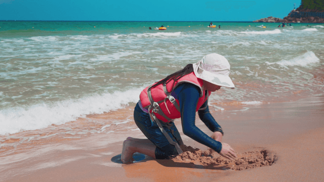 Girl playing with sand on beach