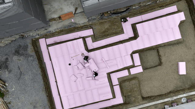Workers installing pink insulation boards