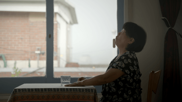Woman drinking water at a table indoors