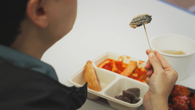 Person eating deep-fried gimari on a skewer