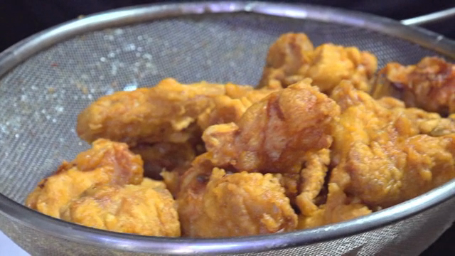 Freshly fried Korean chicken in a strainer