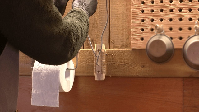 Person adjusting a wooden holder in workshop