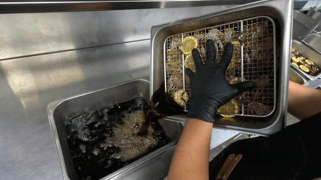 Chef draining soy sauce marinade from marinated crab