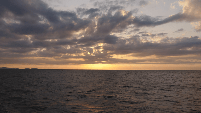 구름이 있는 바다 위의 일몰