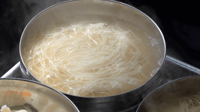 Hot clear broth poured over banquet noodles