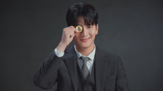 Man holding a Bitcoin coin with a smile