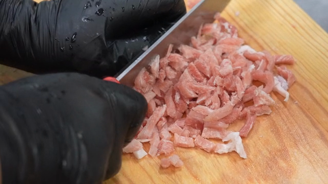 Slicing raw pork on a wooden board