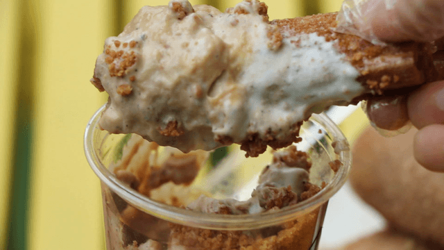 Churro dipped in creamy dessert cup