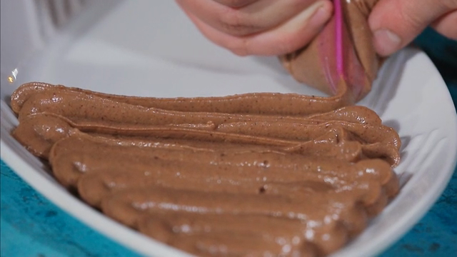 Chocolate mousse being piped onto a plate