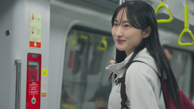 Young woman standing with handrail in subway