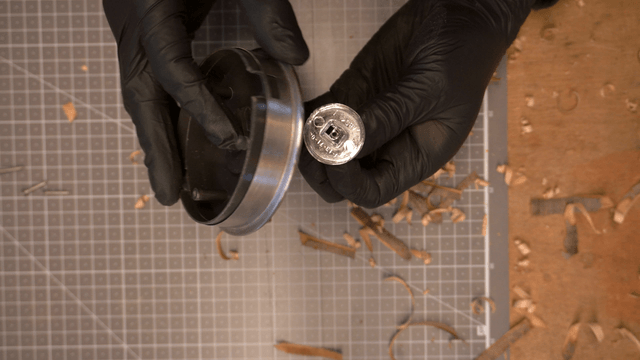 Gloved hands precisely disassembling metal parts