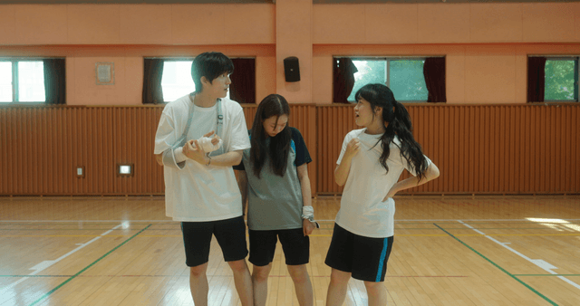 Three friends in a gym having a conversation