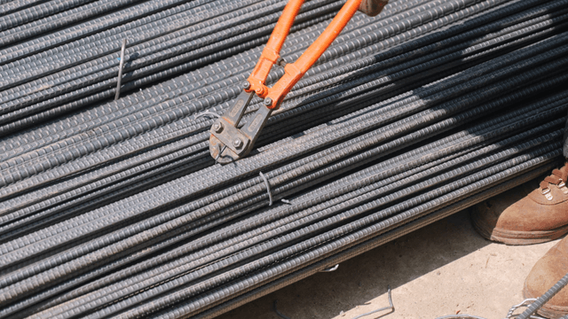 Worker cutting rebar tie with bolt cutter