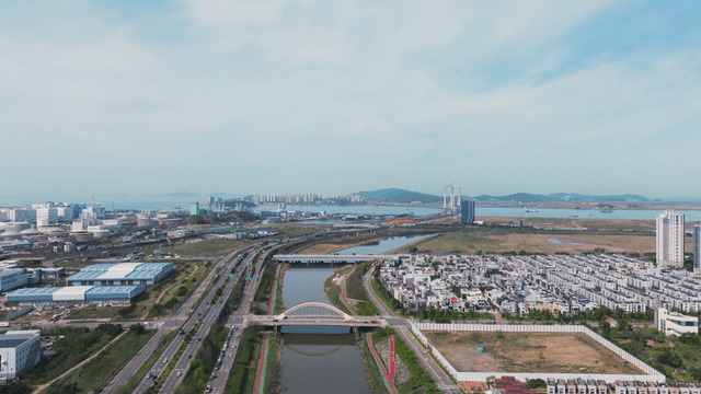 River flowing between multilane road and residential area