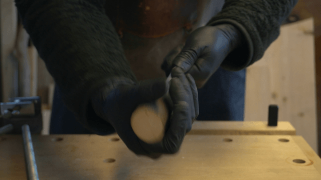 Artisan assembling wooden block and metal rod