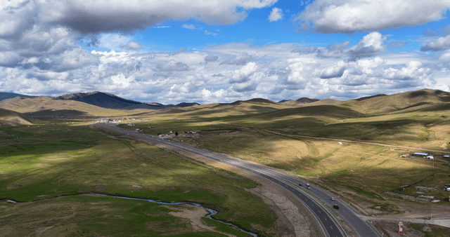 A winding road through vast green hills