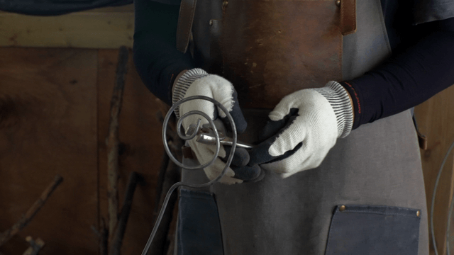 Person shaping metal with tools