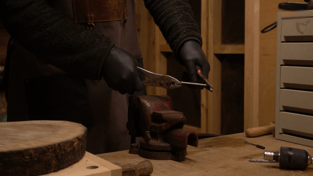 Craftsman bending a metal rod with pliers