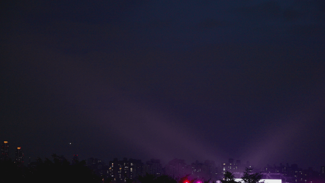 City skyline illuminated by concert lights at night