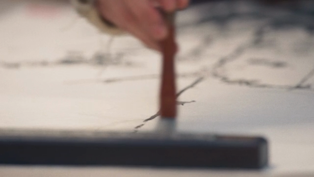 A person painting with a brush on paper
