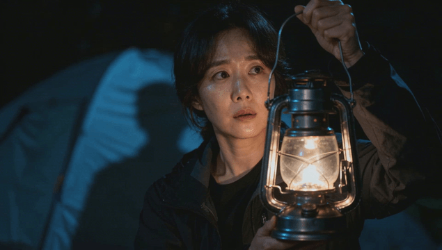 Woman holding lantern at night campsite