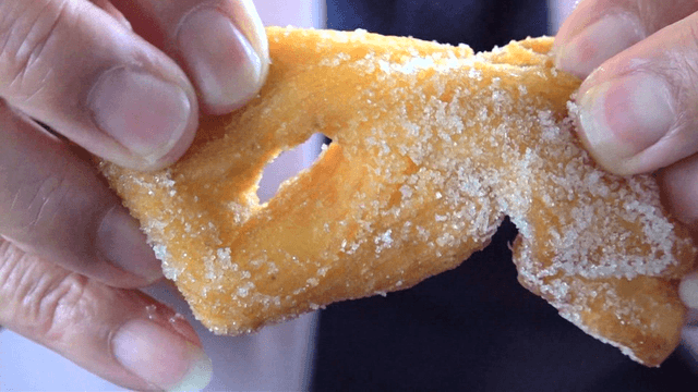 설탕이 잔뜩 묻은 꽈배기를 뜯는 손