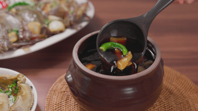 Jar filled with soy sauce marinade for crab
