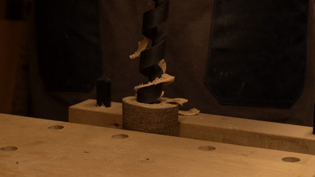 Wooden block being drilled in workshop