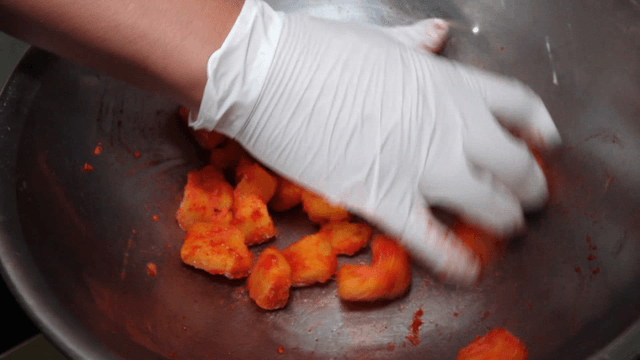 Mango mixed with strawberry powder in stainless bowl