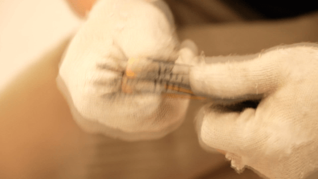 Gloved hand using a utility knife