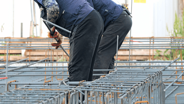 Construction workers handling rebar