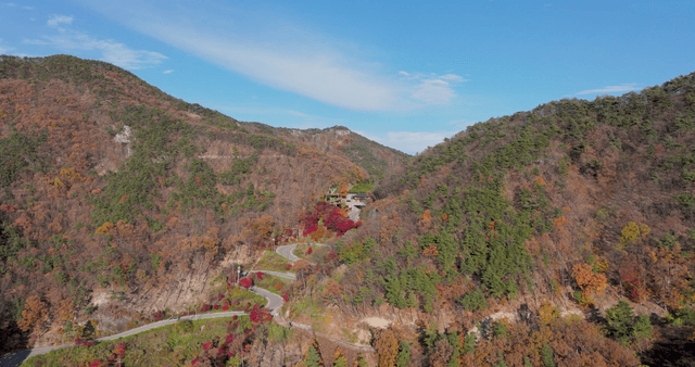 Winding road through autumn foliage mountain