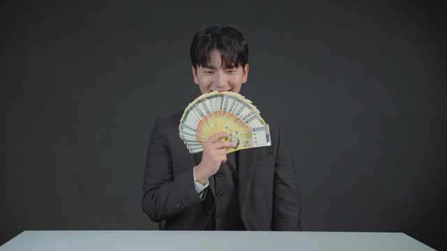 Man in a suit joyfully holding money