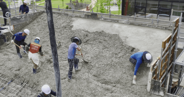 Construction workers pouring concrete