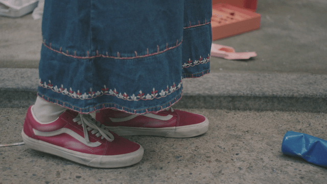 Person wearing red sneakers on a sidewalk