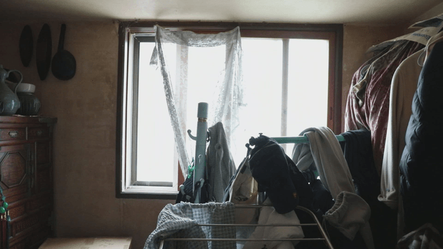 Cluttered room with clothes and window