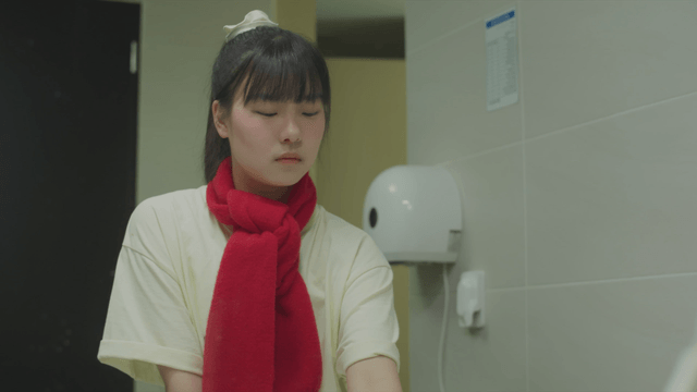 Young woman wearing a scarf washing her hands in the bathroom