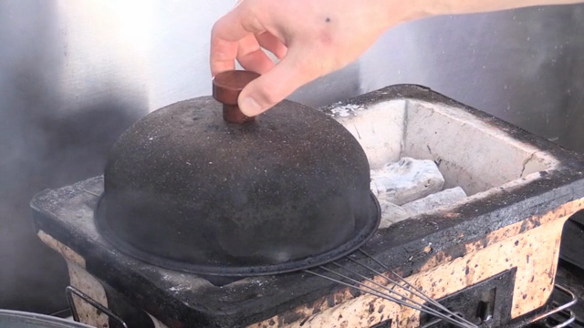 Grilling meat on a charcoal stove