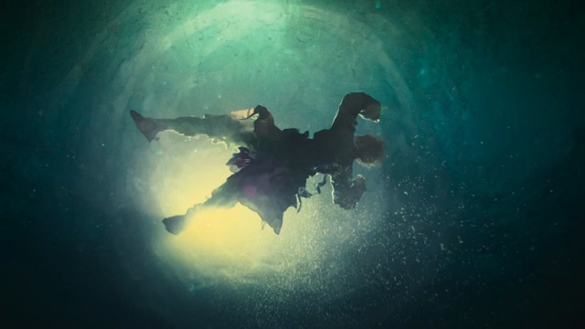 A person floating underwater with light