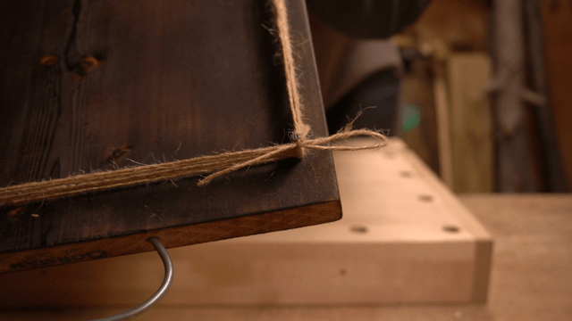 Wooden board with multiple tied ropes and embedded nails