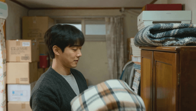 Young man organizing a blanket in his room