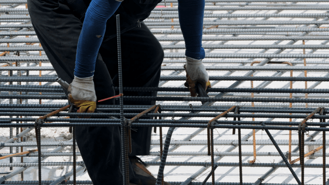 Construction worker handling rebar