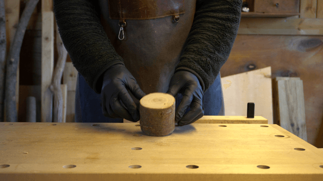 Woodcraft artisan holding a piece of wood in workshop