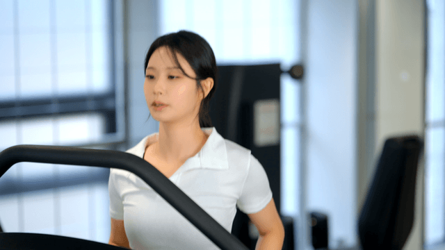 Woman jogging on a treadmill at gym