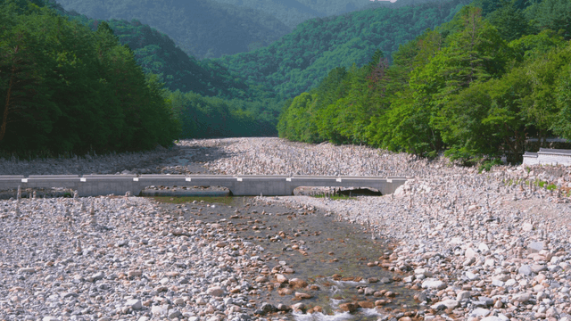 Clear stream and various stone towers below mountain