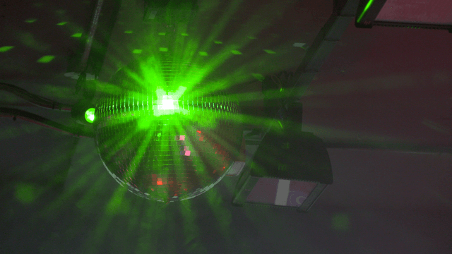 Green disco ball under ceiling lights