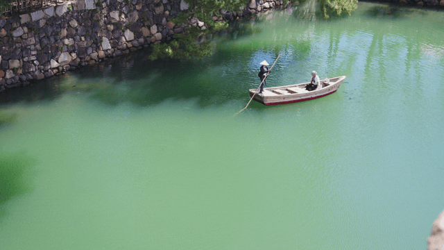 Two people on a boat in a serene river