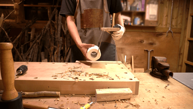 Woodcraft artisan finishing a handmade wooden toilet paper holder