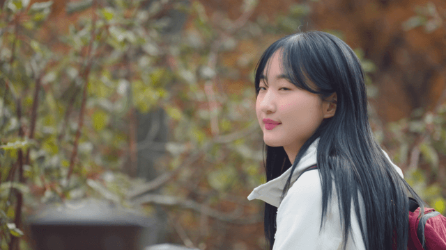 Young woman smiling at autumn forest scenery